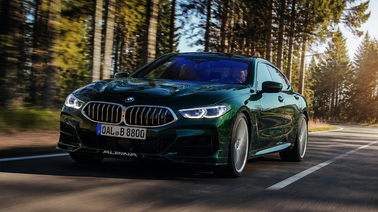 Carro desportivo BMW Alpina verde escuro a circular numa estrada florestal ao entardecer.